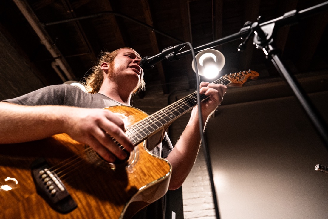Braedan Coghlan playing acoustic guitar